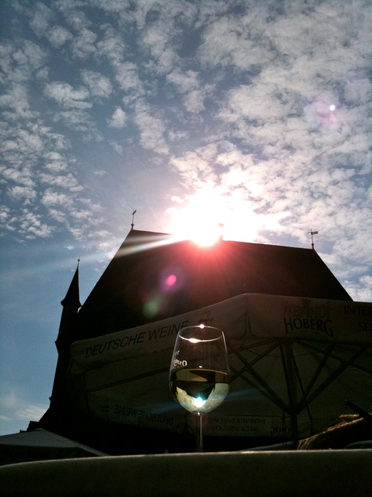 Weinglas vor Rathaus in der Sonne